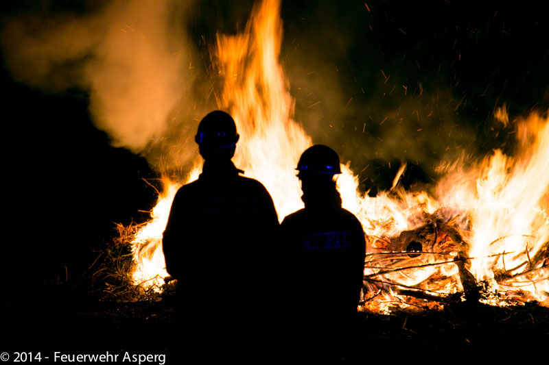 Jugendfeuerwehr vor brennendem Heuballen